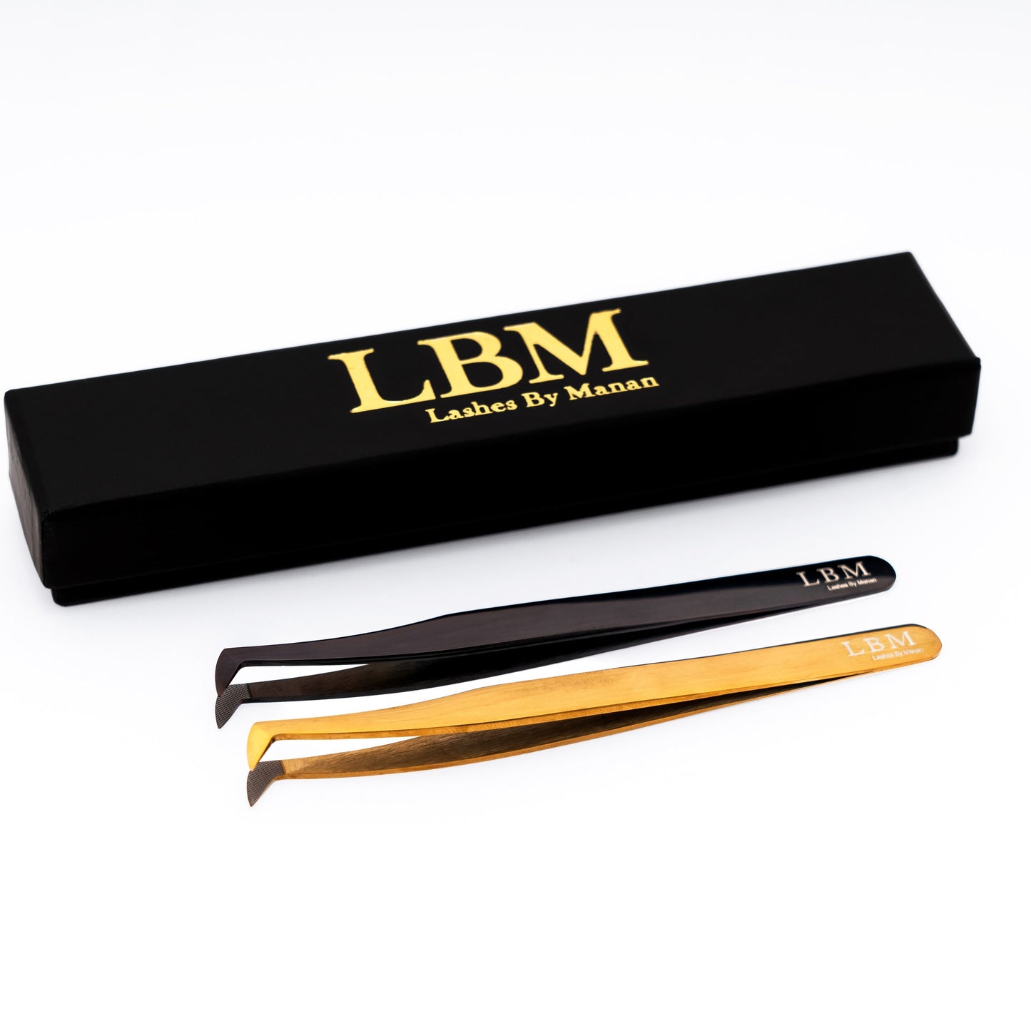 Pair of black and gold eyelash tweezers with LBM branded box on a white background