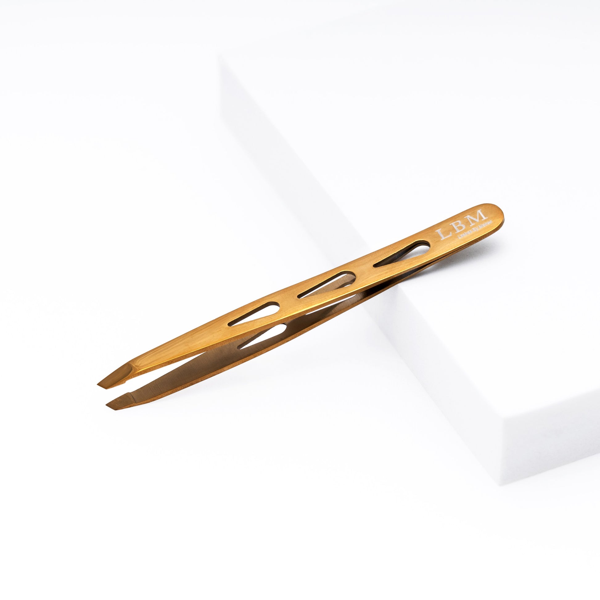 Gold-colored tweezer with 'LBM' branding on a white background