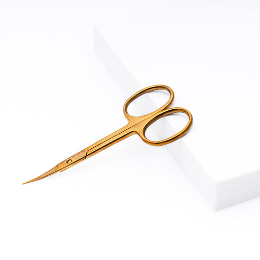 Gold scissors on a white background